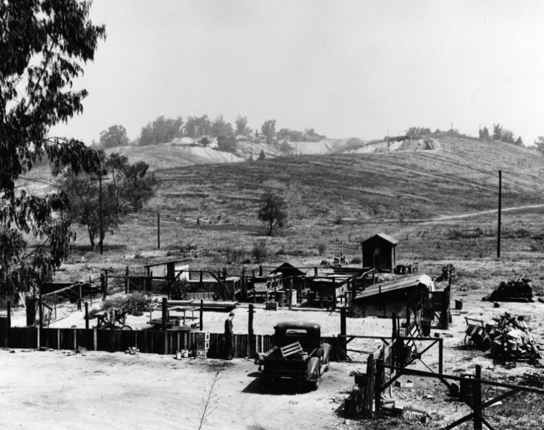 1950: "View of the hillside in the Chavez Ravine area in Elysian Park Heights depicts a country-like setting. The housing in the foreground is fenced and has several animal cages." Courtesy of the Los Angeles Public Library