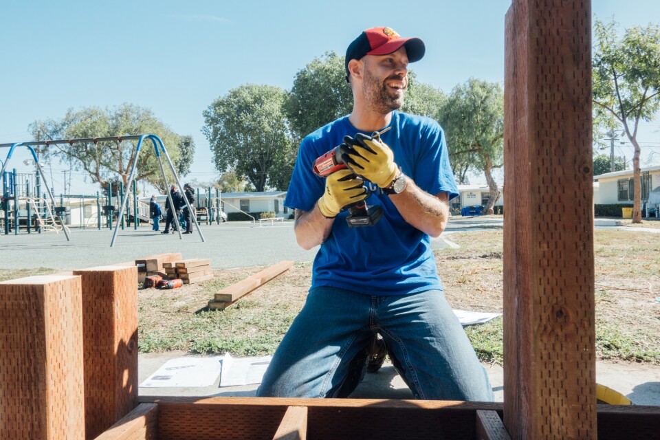 The Mission Continues volunteer Tony Worley wields a drill during a playground revitalization project at Gonzaque Village in Watts.