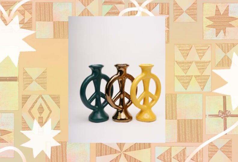 An image shows three thin vases in the shape of peace signs: one in green, one in bronze, and the third in yellow. The images are laid out in a textured taupe pattern that includes stars and stripes, gift boxes and bows.