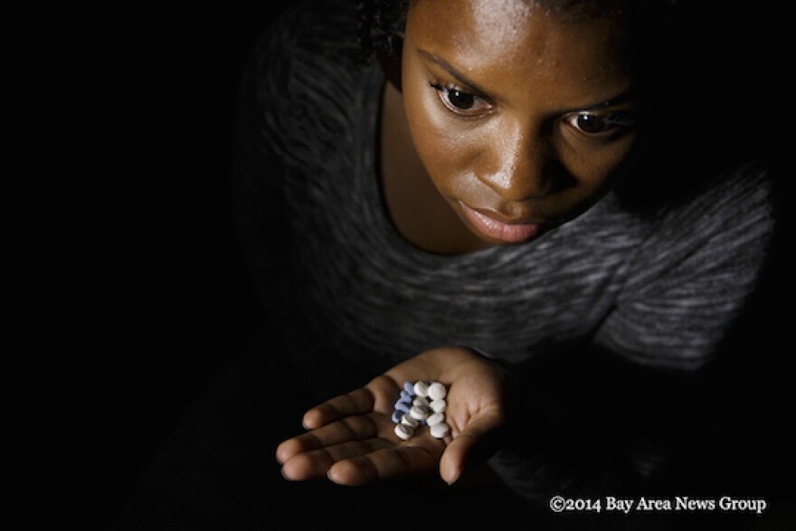 For Joymara Coleman, a 24-year-old student from Hayward, Calif., the medications she was prescribed in foster care "took away the essence" of who she was. Coleman was photographed at her Hayward apartment on Aug. 11, 2014, with two of the psychotropic medications she was prescribed while in foster care. She no longer takes Abilify or trazodone, but keeps them in her apartment as a reminder of what she has overcome. (Dai Sugano/Bay Area News Group)