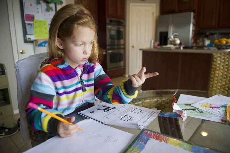 Autumn Watson does her homework in her dining room in Centreville, Maryland, after class at Centreville Elementary on April 30, 2013.