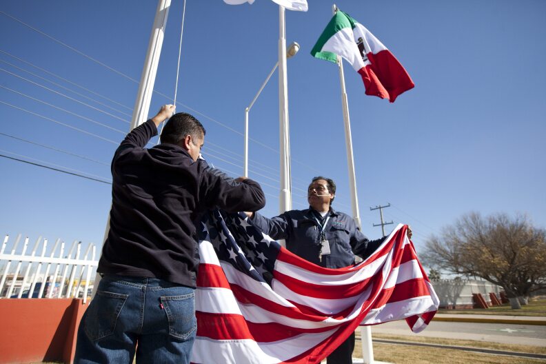 In this Friday, Dec. 27, 2013 photo, workers at one of maquiladoras of the TECMA group prepare to raise the U.S. flag along with the Mexican and TECMA flags in Ciudad Juarez, Mexico. TECMA currently has 14 maquiladora plants in Ciudad Juarez. With the implementation of the North American Free Trade Agreement twenty years ago, many North American and international companies have moved their manufacturing to Mexico at a lower cost and while a majority of Mexicans have seen little benefit in income. While there is undoubtedly a larger middle class today, Mexico is the only major Latin American country where poverty also has grown in recent years. 