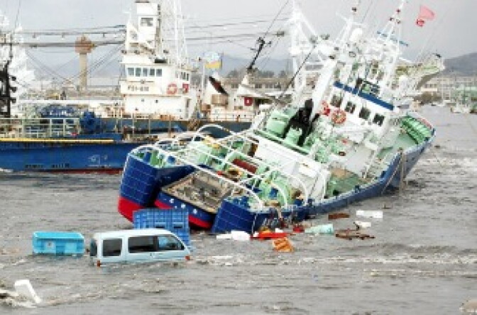 Fishing boats and vehicles are carried by a tsunami wave at Onahama port in Iwaki city, in Fukushima prefecture, northern Japan on March 11, 2011. 