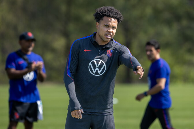 Weston McKennie gestures on a field in a VW jersey.