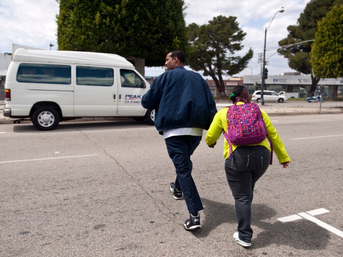 A driver crosses South Market Street with Jamesia Jones. Rehearsals end at 2 p.m. each day.