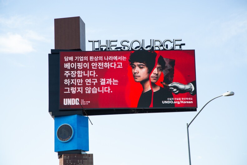 A Korean-language anti-vaping electronic billboard in Buena Park. Above the billboard sit the words "The Source."