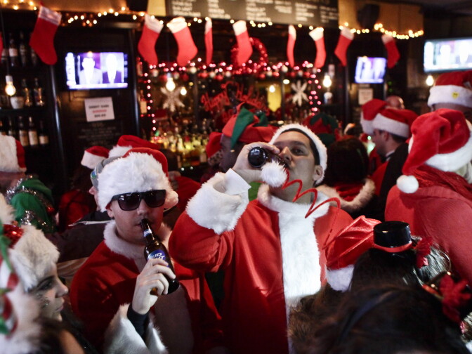 Revelers dressed as Santa Claus drink inside at a bar in the East Village neighborhood during the annual SantaCon bar crawl event on Dec. 14, 2013 in New York City. In New York some community groups have established a 'Santa Free' zone that urges bars not to serve alcoholic beverages to people participating in order to dissuade incidents of public vomiting and urination in the streets.