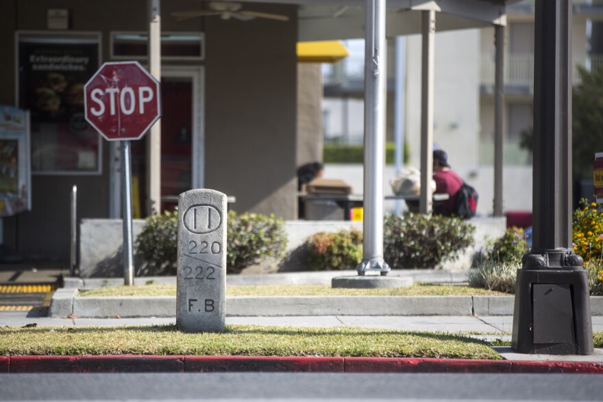 Hidden History's Robert Petersen stands next to a 111-year-old concrete marker on Colorado Boulevard at Holliston Street in Pasadena on Wenesday, June 7, 2017.