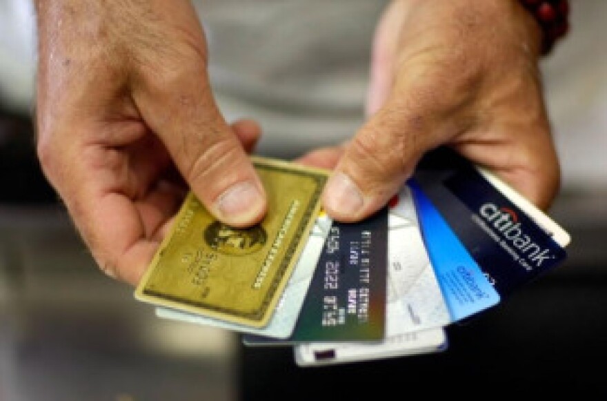 Alain Filiz shows off some of his credit cards as he pays for items at Lorenzo's Italian Market on May 20, 2009 in Miami, Florida. File photo.