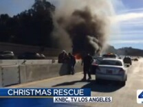 An LAPD officer and good Samaritans rescue a man from a burning car on the 405 freeway on Christmas Day 2013. (Screencap from NBCLA.)