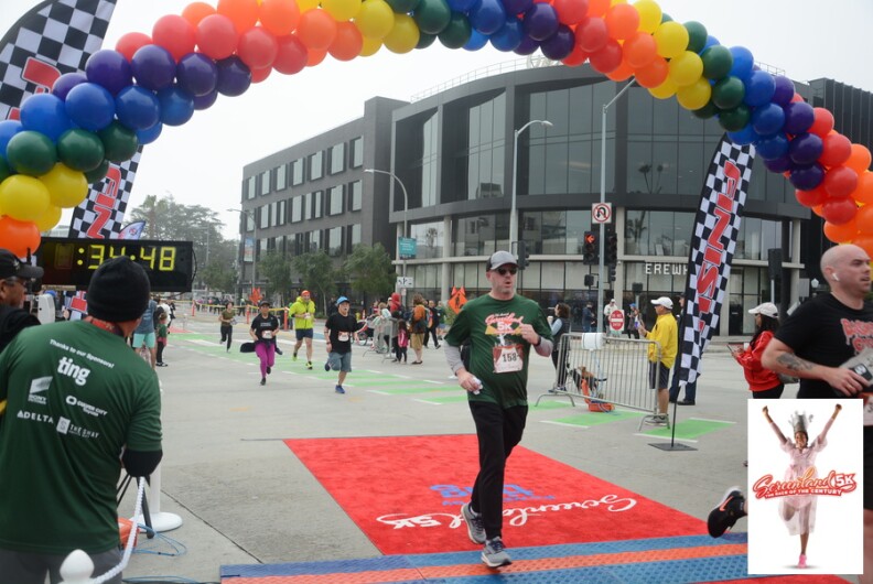 People race to the finish line with a rainbow balloon arch for the Screenland 5k race.