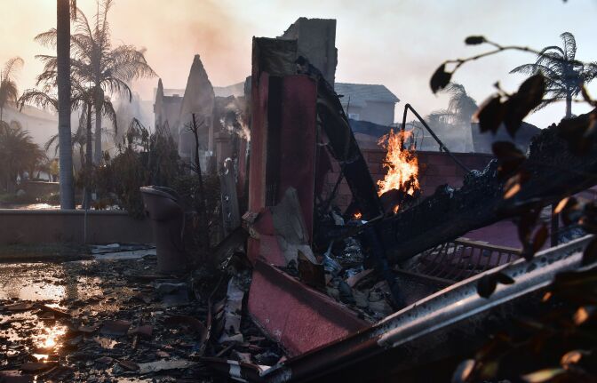 Embers continue to burn amid demolished homes in the Anaheim Hills neighborhood on October 9, 2017, after the Canyon Fire 2 spread quickly through the area destroying homes.