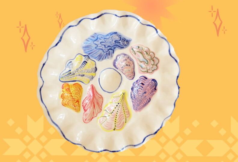 A white plate with curved edges with oyster shells design in different colors