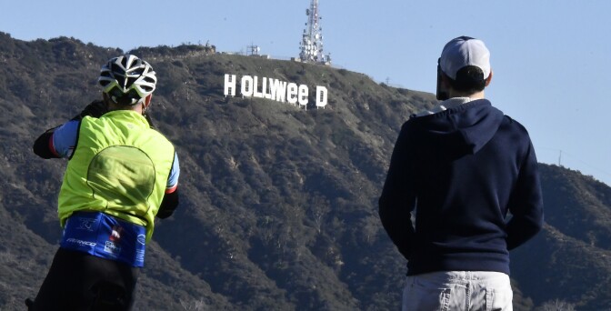 The famous Hollywood sign reads "Hollyweed" after it was vandalized, January 1, 2017. - Police said unidentified thrill-seekers had climbed up and arranged tarps over the two letter "O's" to make them look like "E's," CBS affiliate KCAL reported. Each letter is 45 feet (13.7 meters) high, so the feat would have required not just bravado but considerable athleticism. (Photo by Gene Blevins / AFP) (Photo by GENE BLEVINS/AFP via Getty Images)