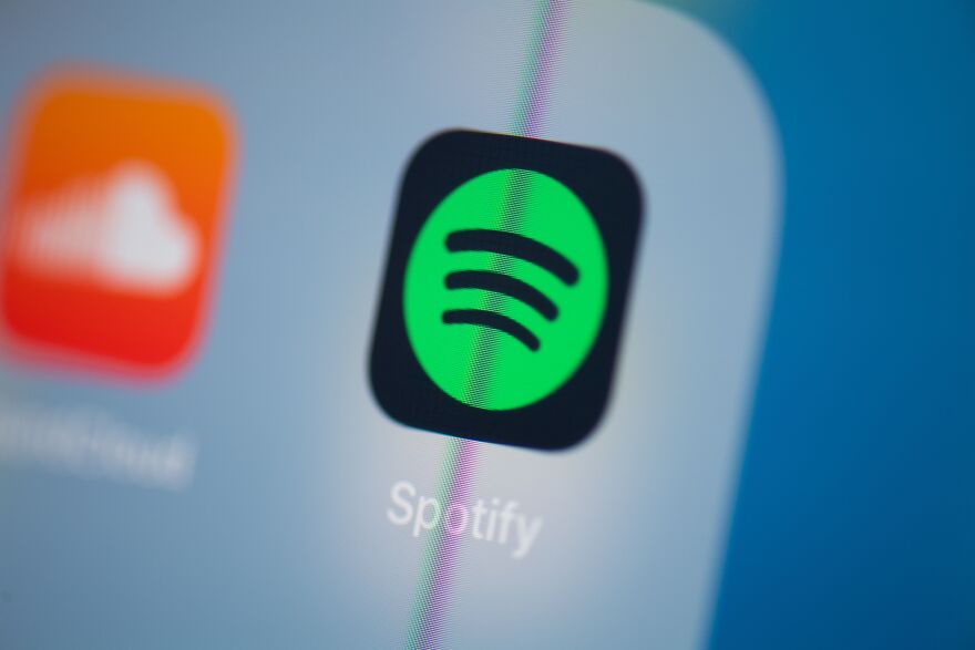 Spotify's logo, seen here on a phone screen, has a green circle with three lines suggesting sound waves.