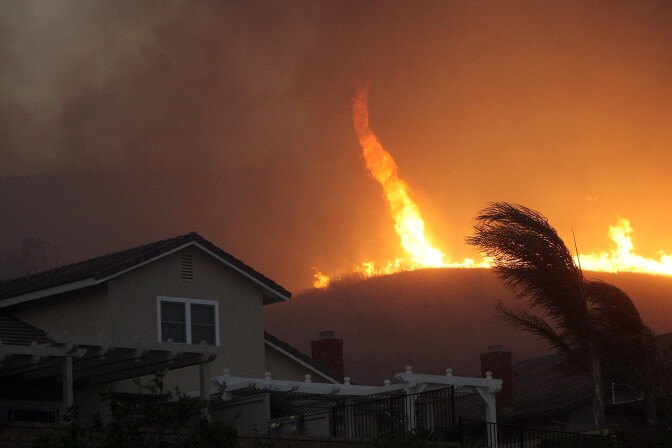 YORBA LINDA, CA - NOVEMBER 15:  A fire tornado comes close to homes during the Corona Fire on November 15, 2008 in Yorba Linda, California. Strong Santa Ana Winds are destroying hundreds of homes and charring thousands of acres around southern California. California Governor Arnold Schwarzenegger has declared states of emergency for the fires.  (Photo by David McNew/Getty Images)