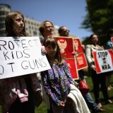 WASHINGTON, DC - APRIL 25:  Anti-gun violence demonstrators, including Rachel Ahrens (L), 13, Abby Ahrens, 8, and their mother Betty Ahrens hold signs condeming the National Rifle Association during a protest in McPhearson Square April 25, 2013 in Washington, DC. Angry with the U.S. Senate's failure to pass an expansion of background checks for people wanting to buy guns, the demonstrators attempted to deliver faux bank checks and crime scene photos to a handful of lobbying firms that represent the NRA.  (Photo by Chip Somodevilla/Getty Images)