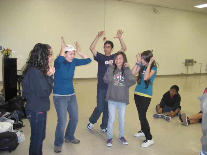 A Cal Arts grad student helps kids learn to mime during a theater arts workshop for English learners.