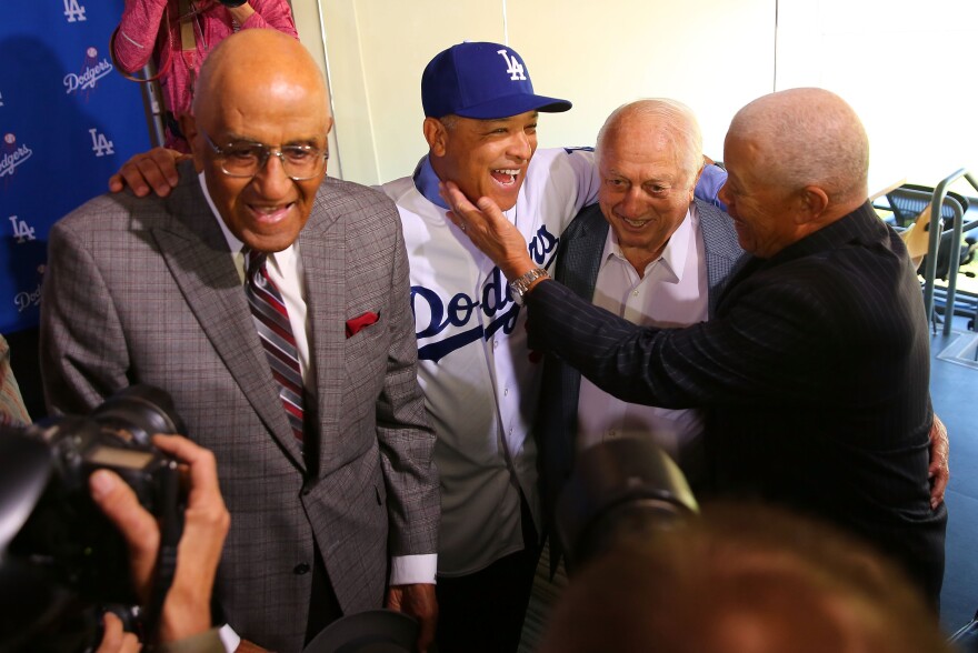 LOS ANGELES, CA - DECEMBER 01:  Former Dodgers player Maury Wills, right, congratulates Dave Roberts on his position as the new Los Angeles Dodgers manager as former Dodgers player Don Newcombe, left, and former Dodgers manager Tommy Lasorda, second from right, look on at Dodger Stadium on December 1, 2015 in Los Angeles, California.  (Photo by Victor Decolongon/Getty Images)