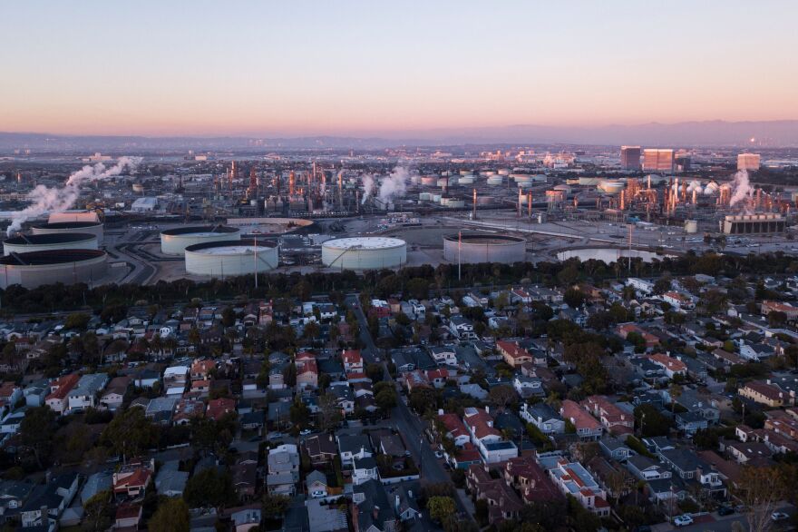An aerial image shows storage tanks at the Chevron Products Company El Segundo Refinery adjacent to a neighborhood of homes at sunset in Manhattan Beach, Calif., on Jan. 24.
