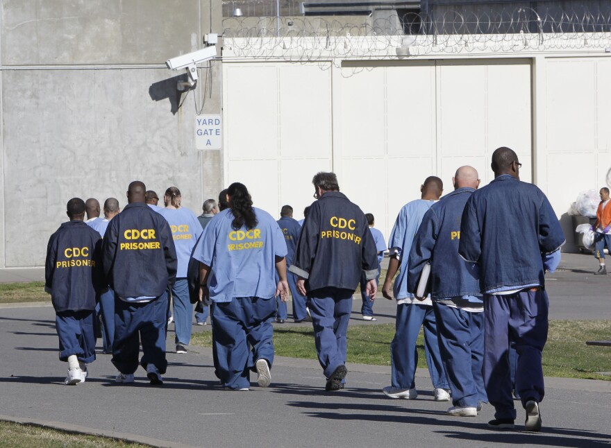 Inmates walk through the exercise yard at California State Prison Sacramento, near Folsom, Calif., in 2013. Gov. Jerry Brown's latest attempt to reduce the state prison population is a ballot initiative unveiled Wednesday, Jan. 27, 2016, that aims to free certain felons earlier and have fewer juveniles tried as adults. (AP Photo/Rich Pedroncelli)