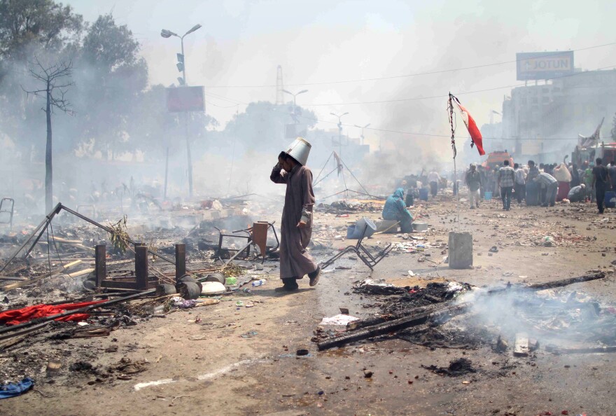 A supporter of Egypt's ousted president Mohamed Morsi walks through the debris following clashes with police in Cairo on August 14, 2013, as security forces backed by bulldozers moved in on two huge pro-Morsi protest camps, launching a long-threatened crackdown that left dozens dead. The clearance operation began shortly after dawn when security forces surrounded the sprawling Rabaa al-Adawiya camp in east Cairo and a similar one at Al-Nahda square, in the centre of the capital.