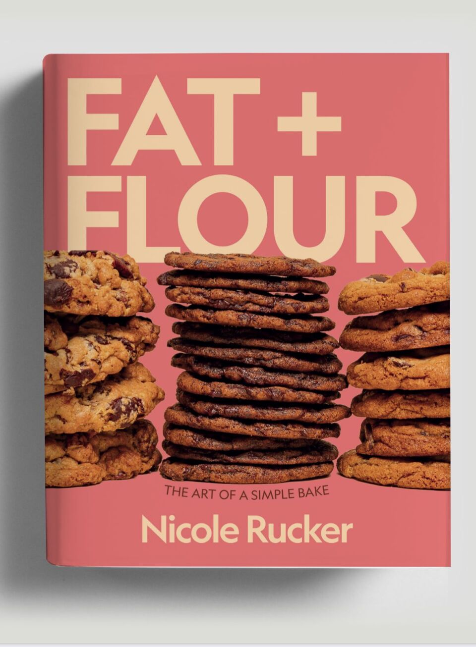 The cover is a cookbook against a white background. It is pale pink with light yellow lettering that reads "Fat + Flour" as its title, with images of three different stacks of various cookies. Underneath, in small black letters, "The Art of a Simple Bake" and the author's name, Nicole Rucker, are displayed. 