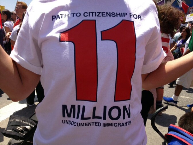 Immigrant advocates filed a lawsuit in Los Angeles Wednesday alleging that immigration agents are filing paperwork to keep arrestees in custody longer without investigating whether they're in the country illegally. (Photo: A May Day protester at a Los Angeles immigration rally wears a "Path to citizenship for 11 million undocumented immigrants" t-shirt, May 1, 2013.)