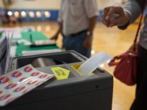 A woman submits her ballot at Estrada Court Community Center in Boyle Heights.
