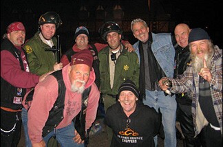 Members of the Sons of God Motorcycle Ministry (Tujunga Chapter), including Michael Kruly, in blue denim vest and black scarf, and chapter president Jim Hoggatt, leaning in, in red hat.