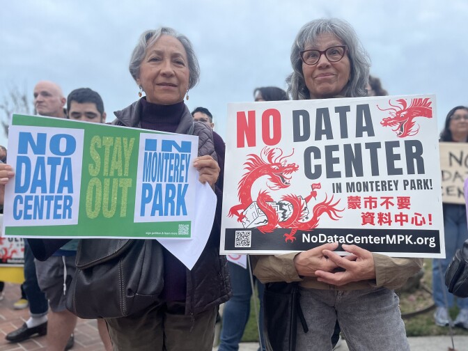 Two women with gray hair carry signs that read "No Data Center."