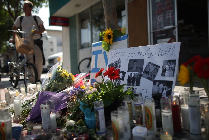 Photos of a victim stand in a makeshift memorial in front of the IV Deli May 25, 2014 in Isla Vista, California. According to reports, 22 year old Elliot Rodger, son of assistant director of the Hunger Games, Elliot Rodger, began his mass killing near the University of California in Santa Babara by stabbing three people to death in an apartment. He then went on to shooting people while driving his BMW and ran down at least one person until crashing with a self-inflicted gunshot wound to the head. Officers found three legally-purchased guns registered to him inside the vehicle. Prior to the murders, Rodger posted YouTube videos declaring his intention to annihilate the girls who rejected him sexually and others in retaliation for his remaining a virgin at age 22. Seven people died, including the Rodger, and seven others wounded, according to authorities.