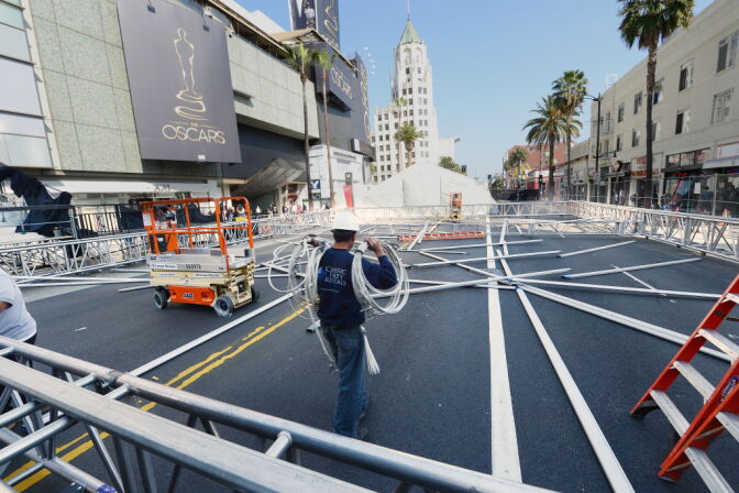 A worker carries building materials on Hollywood Boulevard in preparation for the 85th Academy Awards ceremony, February 18, 2013 in Hollywood, California. A section of Hollywood Boulevard in front of the Dolby Theatre will be closed for the entire week as crews build press risers and fan bleachers and roll out the red carpet for the Academy Awards ceremony, which will take place on February 24 in the Dolby Theatre. 