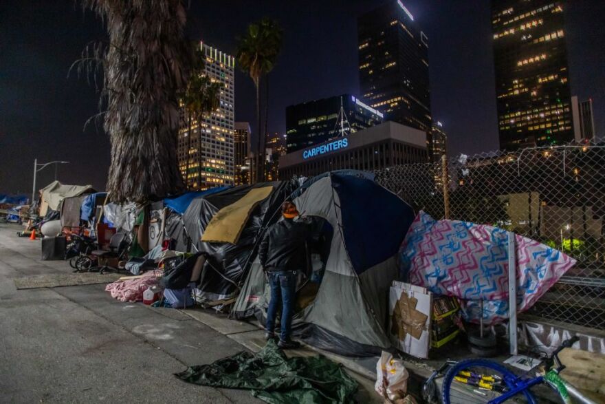 Robert King Geiser, 35 years-old, after 2 years living on the street, stands outside his tent next to the 110 Freeway, during the novel Coronavirus, COVID-19, pandemic in Los Angeles California on May 25, 2020. - On May 22, 2020 a federal judge issued a preliminary order requiring that  homeless people living under Los Angeles freeway overpasses and underpasses, be relocated for health and safety reasons. (Photo by Apu GOMES / AFP) (Photo by APU GOMES/AFP via Getty Images)