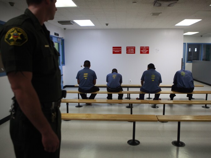 An Orange County Sheriff's deputy keeps a watch over a group of immigration detainees in the medical and dental care area at the Theo Lacy Facility in Orange, Calif., Tuesday, Sept. 28, 2010. Hundreds of detained immigrants are being transferred to Orange County jails, and more are on the way, under a deal with the federal government that would bring the cash-strapped Orange County Sheriff's Department up to $30 million a year, a newspaper reported Sunday. (AP Photo/Jae C. Hong)
