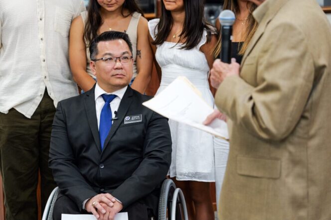 A man in suit sitting in a wheelchair 