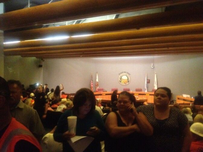 City Council members in a workshop session at Tuesday evening. Outside, hundreds of protesters bang on and peek in doors.