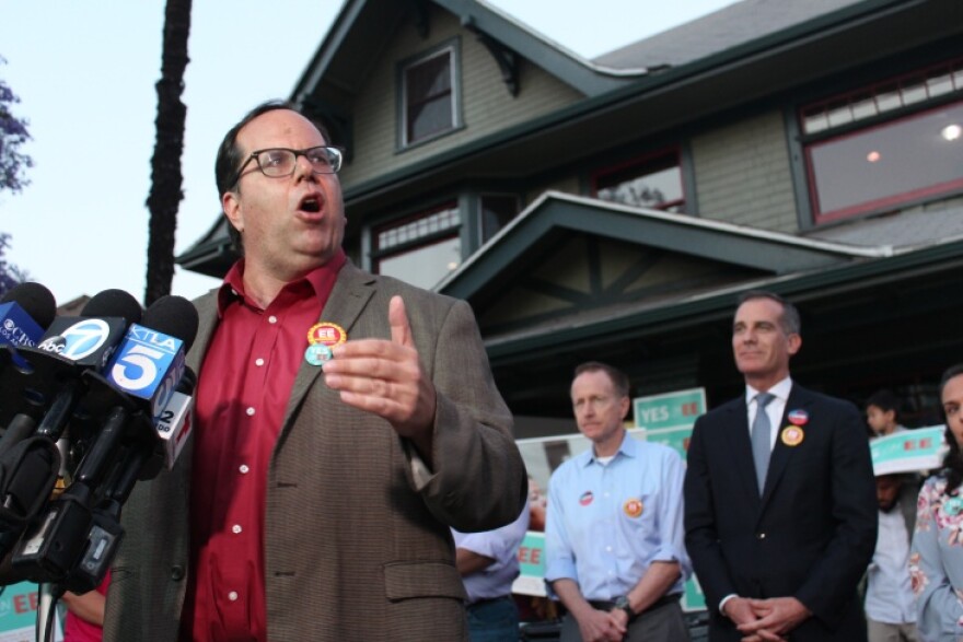 United Teachers Los Angeles president Alex Caputo-Pearl (left) speaks at a gathering of Measure EE supporters after polls close on Tuesday evening, June 4, 2019, as L.A. Unified School District Superintendent Austin Beutner (center, at back) and L.A. Mayor Eric Garcetti (right) look on