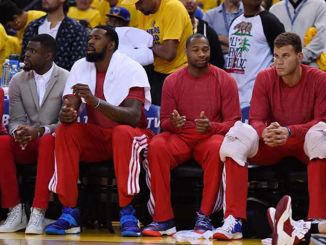 OAKLAND, CA - APRIL 27:  Los Angeles Clippers players sit on the bench wearing their warm-up tops inside out against the Golden State Warriors in Game Four of the Western Conference Quarterfinals during the 2014 NBA Playoffs at ORACLE Arena on April 27, 2014 in Oakland, California. The players wore theirs warm up this way in protest of owner Donald Sterling's racially insensitive remarks. NOTE TO USER: User expressly acknowledges and agrees that, by downloading and or using this photograph, User is consenting to the terms and conditions of the Getty Images License Agreement.  (Photo by Thearon W. Henderson/Getty Images)
