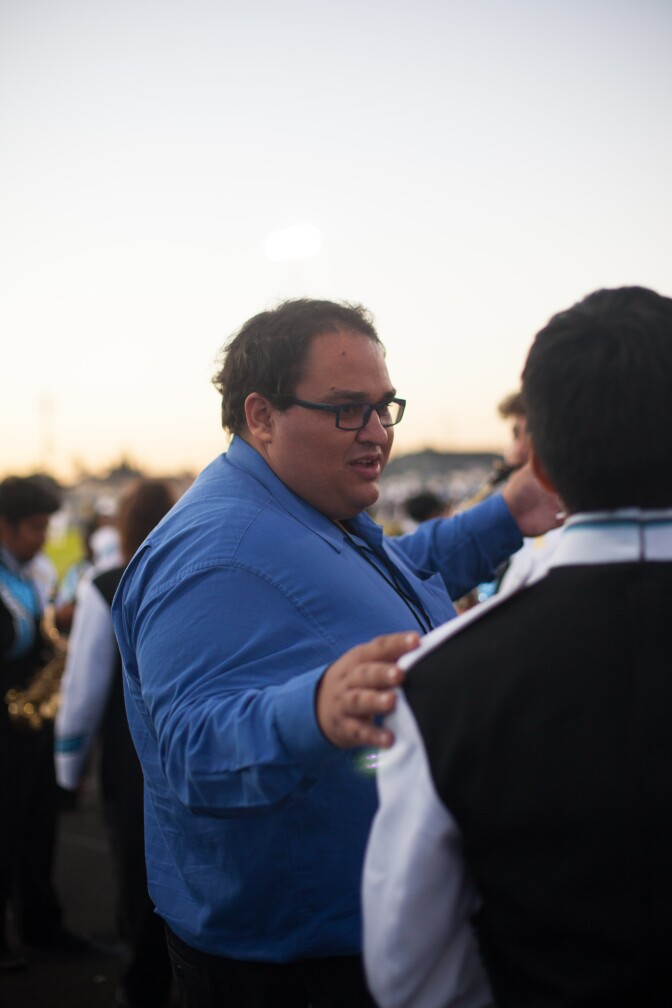 Matthew Stickman, co-director of Locke High School's band, speaks to a student at the homecoming game in October 2017.