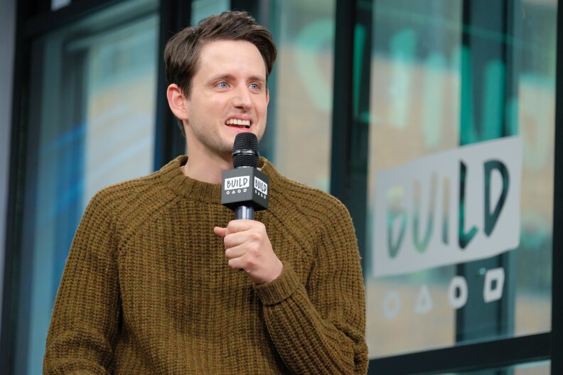 Zach Woods with a microphone in his hand.