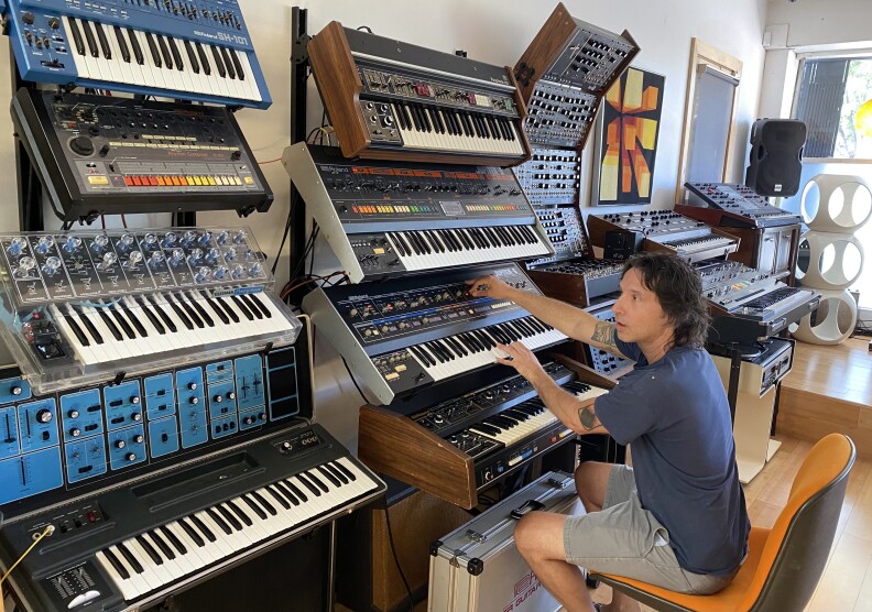 Lance Hill plays a vintage synthesizer at the Vintage Synth Museum in Highland Park