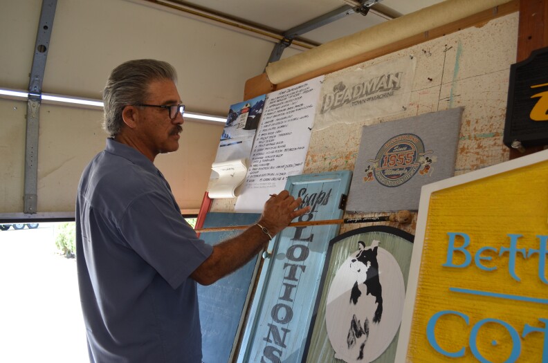 Patrick Smith demonstrates the use of a mahlstick. Painters use them to steady and support their painting hand. 