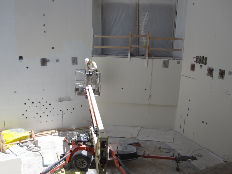 A construction worker paints walls at the Maryland Proton Treatment Center in Baltimore. Each of the center's five rooms will contain a massive piece of equipment that will rotate around a cancer patient to deliver a special kind of radiation.