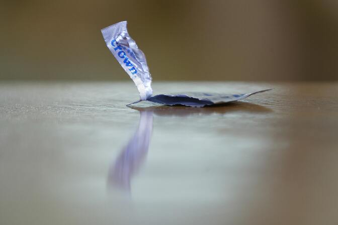 An empty condom package rests on a table during the shooting of a porn scene for the adult film production company Vivid, 18 May 2004, on the set in Canoga Park, California, about 40 miles west of Los Angeles. A moratorium on film production in the adult movie industry was set to end Friday, Sept. 20, following an HIV scare in which two actors tested positive in a month.