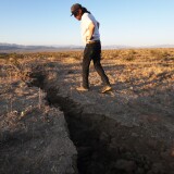 RIDGECREST, CALIFORNIA - JULY 04: A local resident inspects a fissure in the earth after a 6.4 magnitude earthquake struck the area on July 4, 2019 near Ridgecrest, California. The earthquake was the largest to strike Southern California in 20 years with the epicenter located in a remote area of the Mojave Desert. The temblor was felt by residents across much of Southern California. (Photo by Mario Tama/Getty Images)