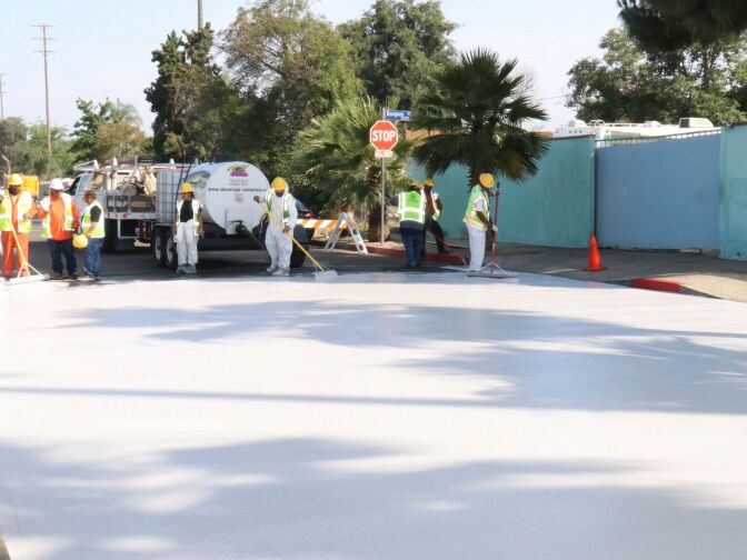 City employees paint a section of Beachy Ave in Pacoima a light gray in May as part of a pilot project to test out "cool pavement."
