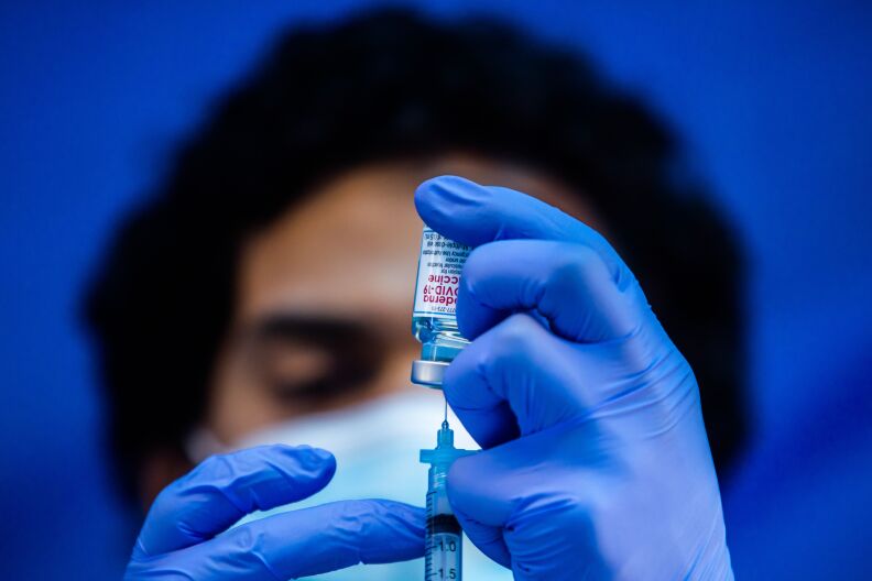 Medical worker Robert Gilbertson loads a syringe with the Moderna Covid-19 vaccine to be administered by nurses at a vaccination site at Kedren Community Health Center, in South Central Los Angeles, California on February 16, 2021. (Photo by Apu GOMES / AFP) (Photo by APU GOMES/AFP via Getty Images)