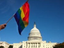A demonstrator waves a rainbow flag in front of the US Capitol in Washington D.C.