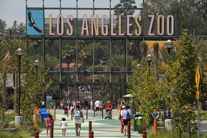 Visitors arrive at the main entrance to the Los Angeles Zoo in Los Angeles, California August 12, 2011.  The Los Angeles City Council voted today to pursue plans leading to a possible privatization of the zoo, an idea described by its chief advocate as ``the only model'' available to the cash-strapped city if it wishes to keep the attraction open. City officials say the change would save nearly $20 million over the next five years but opponents of the plan question the savings and warn that privatization could mean steeper ticket prices for the zoo's 1.5 million annual visitors and less transparency when it comes to animal welfare.  AFP PHOTO / Robyn Beck (Photo credit should read ROBYN BECK/AFP/Getty Images)